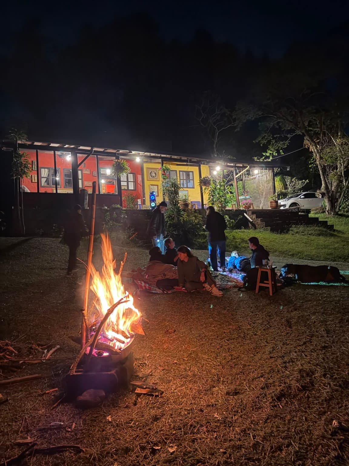 A group around the bonfire in front of La Julia's illuminated house