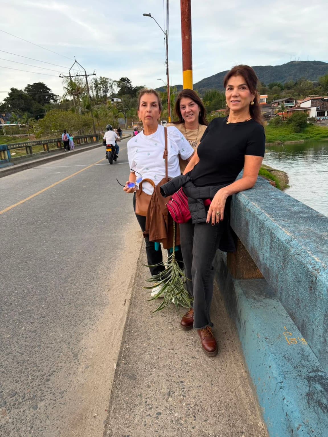 Three people on a bridge in Guatapé